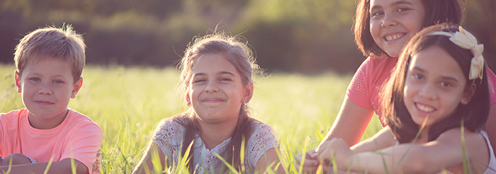 children smiling in a field